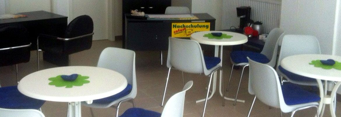 Der zweite Seminarraum mit weißen Tischen und blauen Stühlen